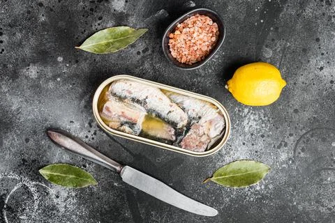Canned sardine in oil, on black dark stone table background, top view flat la Stock Photos