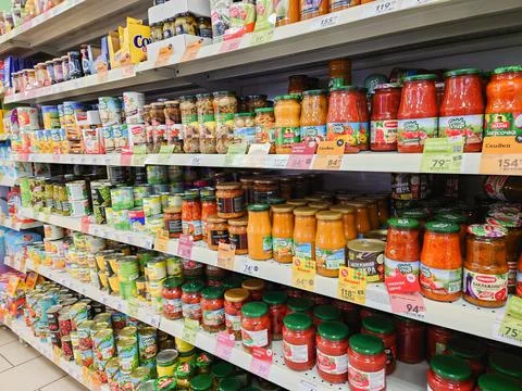 Canned vegetables and fruit in cans on the shelves of a grocery supermarket. Stock Photos