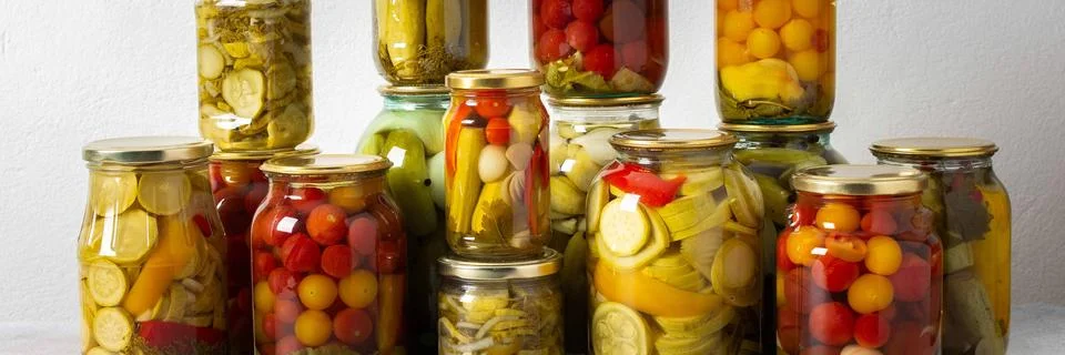 Canning is a common activity in the kitchen as jars filled with vegetables an Stock Photos