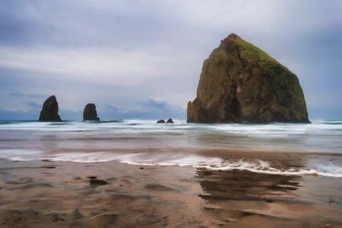 Cannon Beach Haystack Rock and Needles under cloudy skies Stock Photos