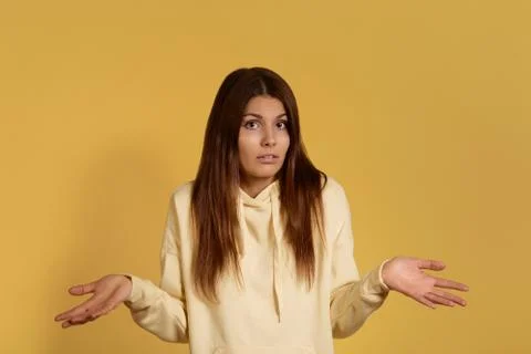Cannot answer question. Confused hesitant caucasian woman in yellow hoodie sp Stock Photos