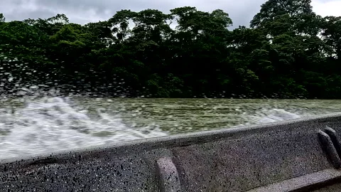 A canoe is running fast over a tropical river with water splashing up Видео 336916154