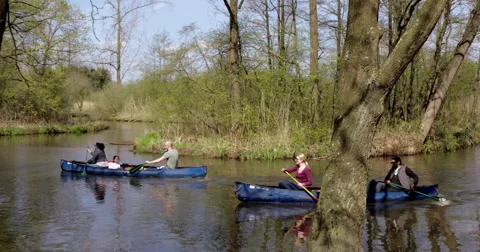 Canoeing group paddling and singing a song at river curve  2, 4K Stock Footage 49274437