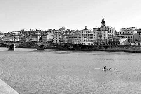 Canoeist navigates the Arno River while surrounded by Florence's historic b.. Stock Photos