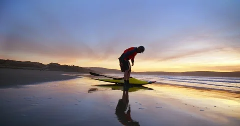 Canoeist sitting on the beach at sunset. 스톡 동영상 88373534