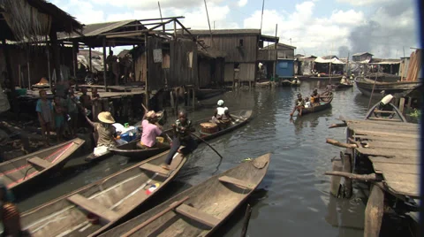 Canoes on busy waterway in Lagos slum. Stock Footage