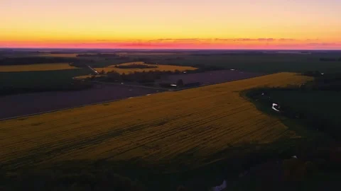 Canola fields glowing gold at sunset, aerial view over rural farmland horizon Vídeos de archivo 332630147