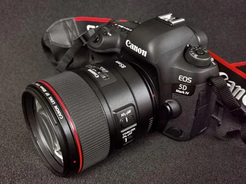 Canon 5D Mark IV camera with Canon EF 85mm f 1.4L IS USM lens on a black ba Stock Photos