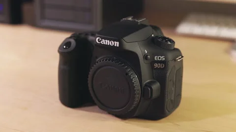 Canon EOS 90D Digital DSLR Camera sitting on Desk - Motion Control Jib Shot Stock Footage 228709217