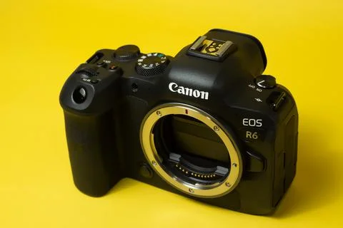 Canon r6 digital camera close-up, yellow background, glare Stock Photos