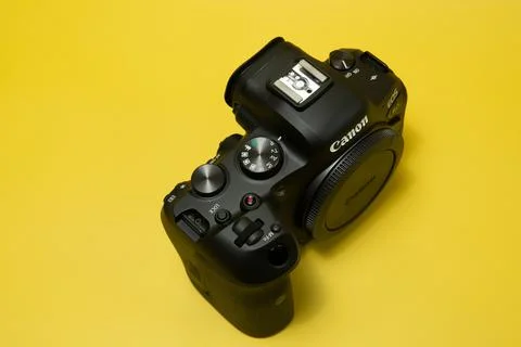 Canon r6 digital camera close-up, yellow background, glare Stock Photos