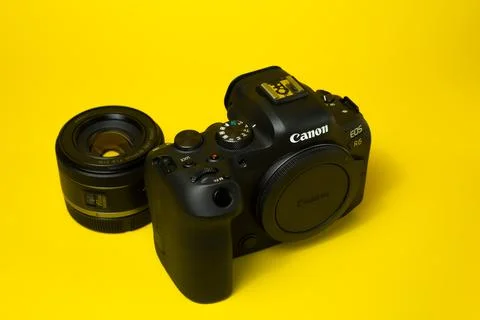 Canon r6 digital camera close-up, yellow background, glare Stock Photos