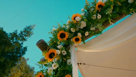 A canopy stands under the sky and decorated with sun flowers and LED lamps. Stock-Footage 242015849
