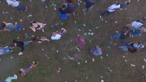 Cans and waste are in the grass, peopledance on after party, shot from above Stock Footage 106595594