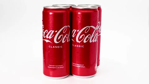 Cans of classic Coca-Cola rotate on a wh... | Stock Video | Pond5