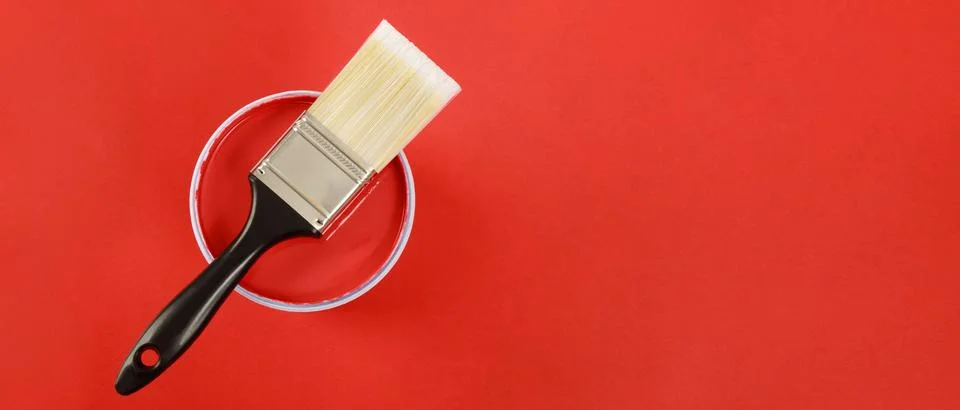 The cans of interior wall paint is placed on a red background. Stock Photos