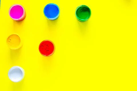 Cans of multi-colored paint are arranged in a triangle in the upper corner of Stock Photos