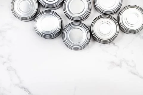 Cans of preserves on a marble background with copy space in a top view Foto stock