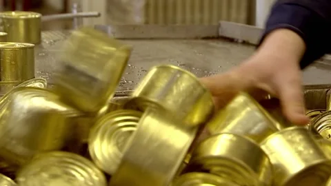 Cans rake from the conveyor belt into a box Stock Footage 102060606