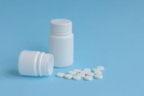 Cans of tablets on a blue background, concept of drugs, space for text Stock Photos
