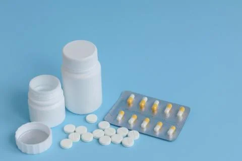 Cans of tablets on a blue background, concept of drugs, space for text Stock Photos