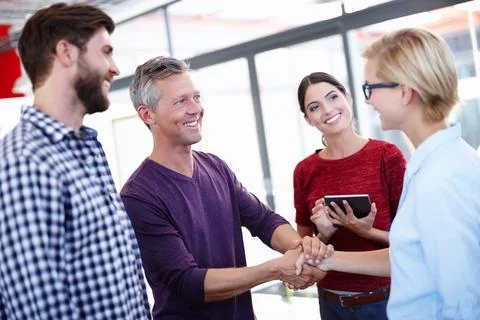 Cant wait to work with you. two coworkers shaking hands. Stock Photos