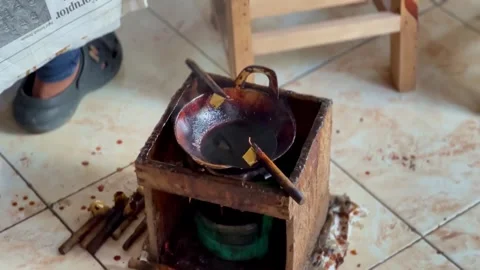 The "canting" tool is in a small pan filled with hot liquid wax. Tools for Stock Footage 278868617