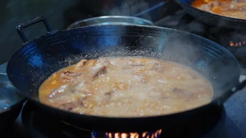 Cantonese dish Drunken Goose is cooked in a large iron pot over an open fire at Stock Footage 346672074