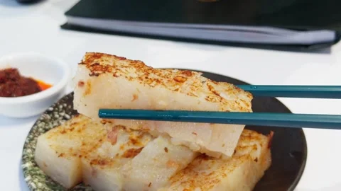Cantonese Pan Fried Turnip Radish Cake Lifted by Chopsticks Close-Up Stock Footage 339399325