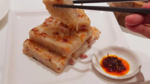 Cantonese Pan Fried Turnip Radish Cake Lifted by Chopsticks with Chili Sauce Stock Footage 339399768