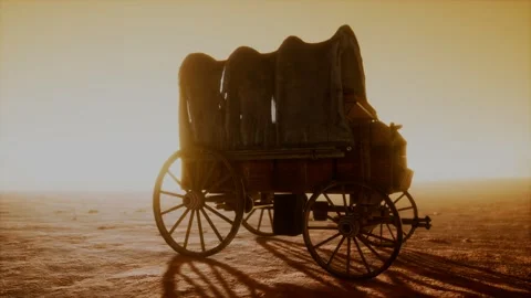 Canvas covered retro wagon in desert at sunset Stock Footage 135893150