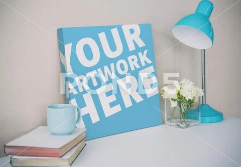 Canvas with flower vase, table lamp and books on desk PSD Template