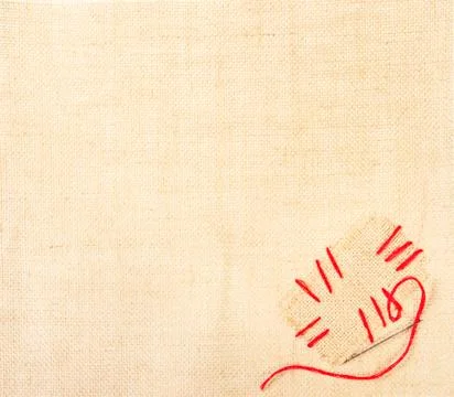Canvas with stiched patch and needle on burlap background. Sackcloth label 스톡 사진