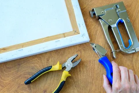 Canvas Stretching Process with Stapler, Pliers, and Remover Tool on Wooden .. Stockfoto's