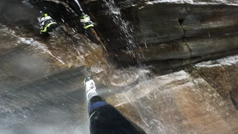 Canyoneering repell down slippery rocks in waterfall in Ticino Switzerland pop s Видео 221470432