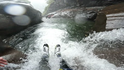 Canyoning Canyoneering slides down waterfall Switzerland tourism adventure Stock Footage 221473258