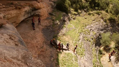 Canyoning group abseiling into a Canyon Stock Footage 98244678