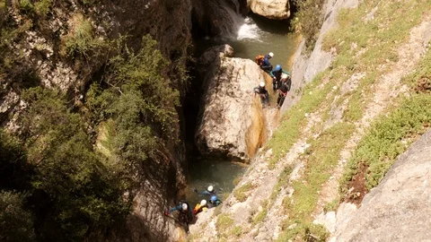 Canyoning group climbing down in the Canyon -medium shot Stock Footage 98423881