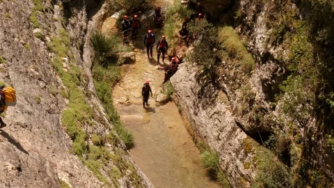 Canyoning group waiting in river Stock Footage 98418283