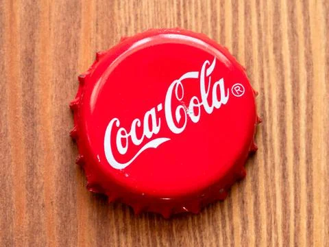 Cap from Coca-Cola bottle close up on wooden table Stock Photos