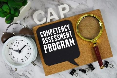 CAP Competency Assessment Program text with alarm clock and magnifying glas.. Stock-Fotos