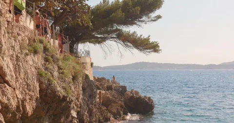 Cap d'Ail coastal path cliffs and swimmers on the French Riviera Stock Footage 343440984