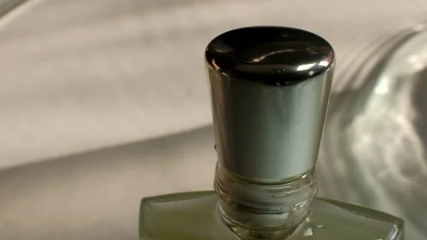 The cap of a perfume bottle on the background of waves of water. Low key Light Stock Footage 150330658