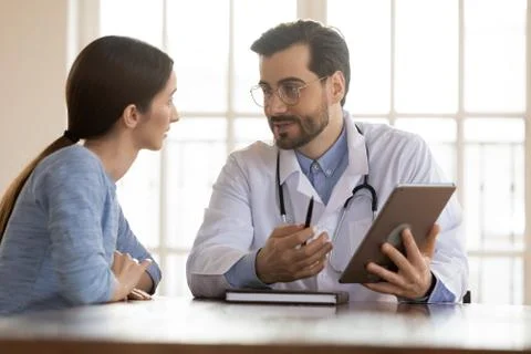 Capable general practitioner demonstrating patient test results in electronic Stock Photos