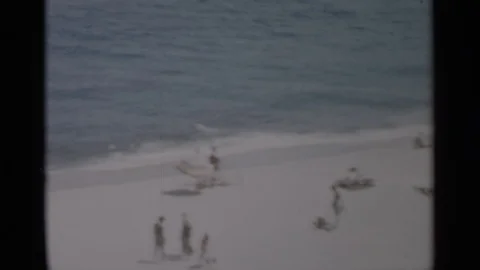 CAPE COD MASSACHUSETTS-1956: Couple Looking At People Walking On Beach On A 스톡 동영상 125304082