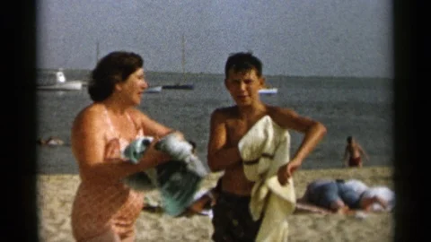 CAPE COD MASSACHUSETTS-1956: Couple Drying Off At The Beach And Old Man Sitting Stock Footage 125304645