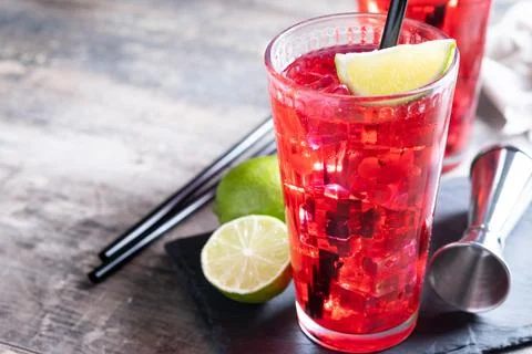 Cape Codder cocktail with vodka, cranberry juice and lime on wooden table Stock Photos