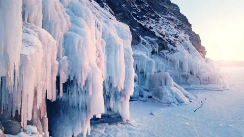 Cape with ice and icicles on winter Baikal lake at sunset Video stock 219955331