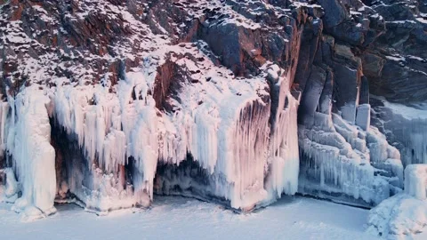 Cape with ice and icicles on winter Baikal lake at sunset. Stock Footage 219964879