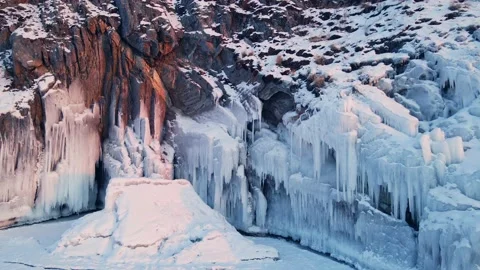 Cape with ice and icicles on winter Baikal lake at sunset. Stock Footage 223124040